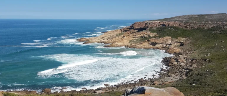 Turquoise waves breaking against a rocky point on the Mossel Bay coast, Western Cape