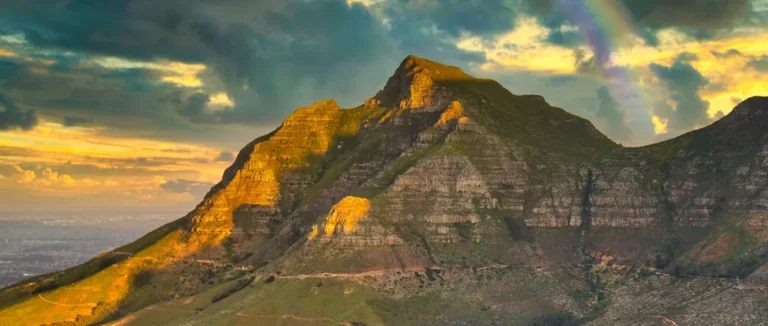Golden evening light and a rainbow over Devil's Peak, Cape Town