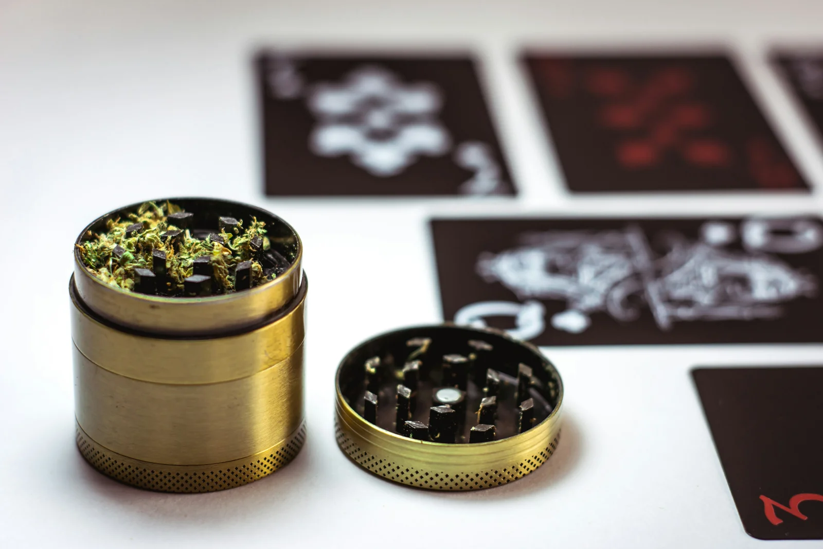 Close-up of a green herb grinder with ground cannabis inside