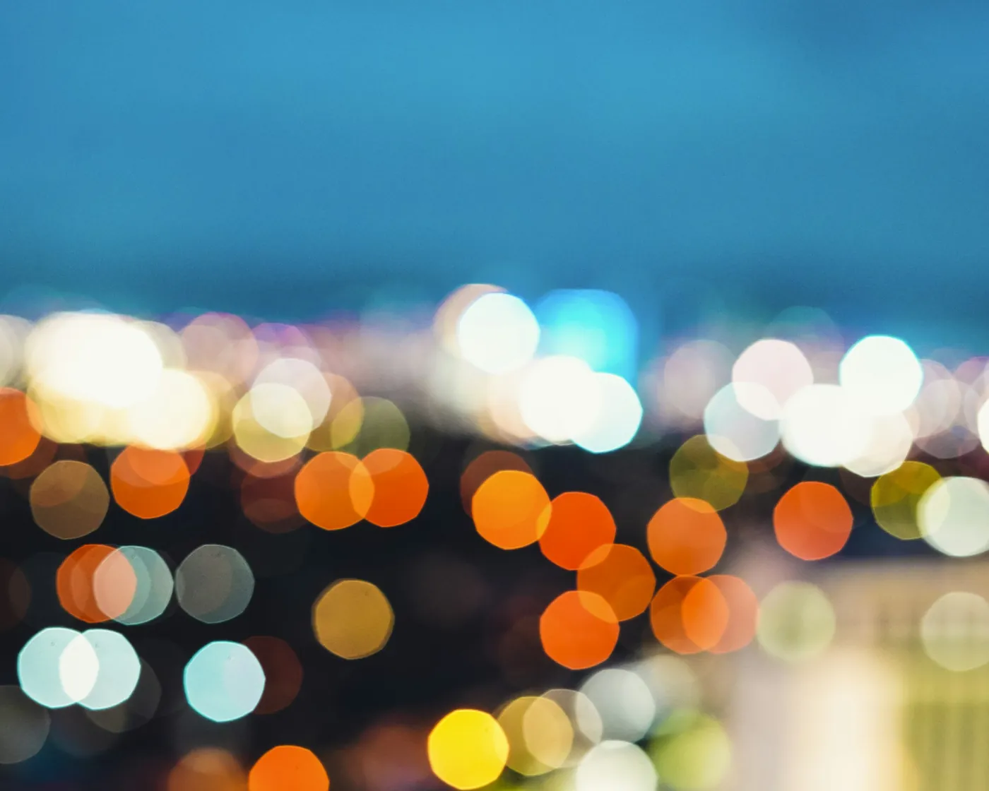 Blurred orange, white and teal city lights at night, no people
