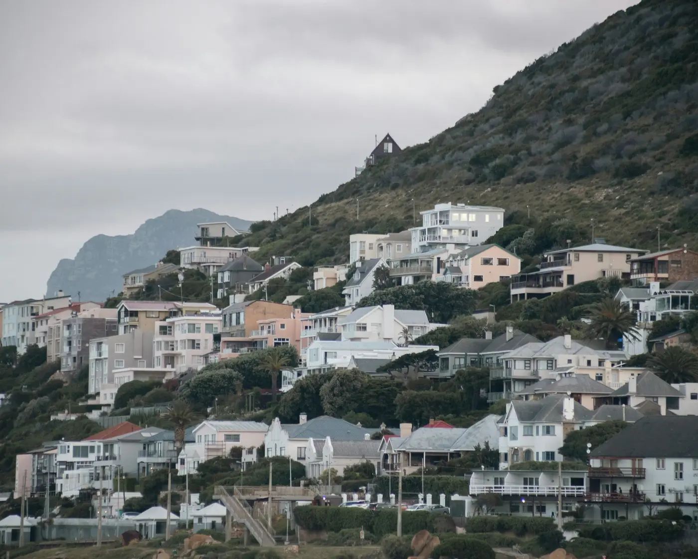 Houses climbing a hillside above Fish Hoek, Cape Town, in overcast light