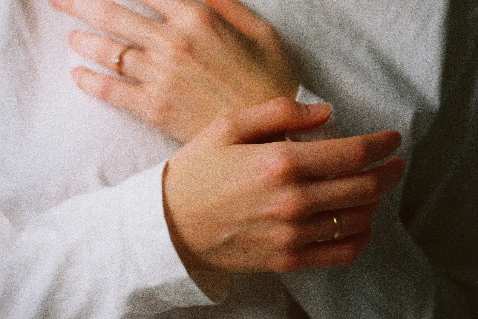 Two hands crossed gently over the chest, resting in a slow breath