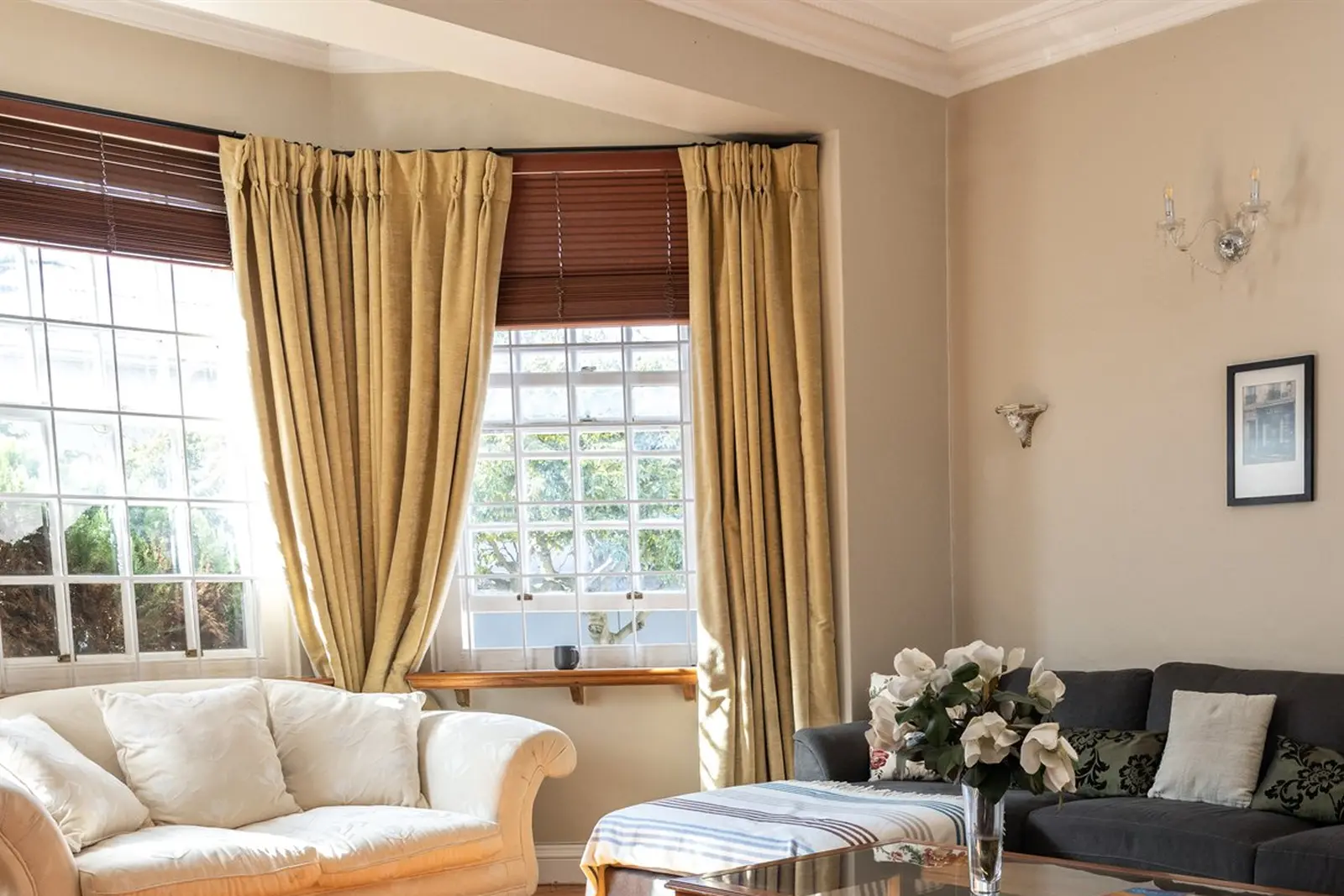A bright lounge with cream sofas and bay windows at the centre in Lakeside