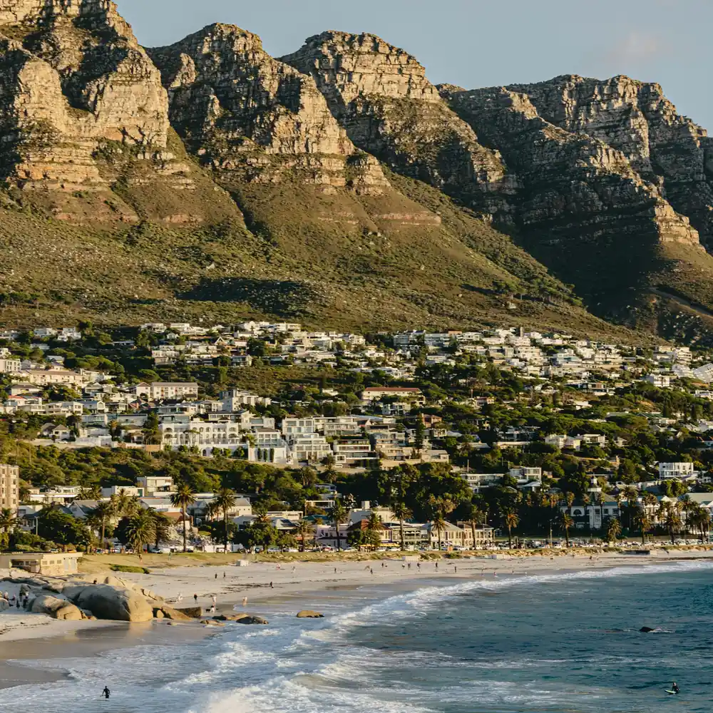 A calm beach with mountains in the background under soft morning light