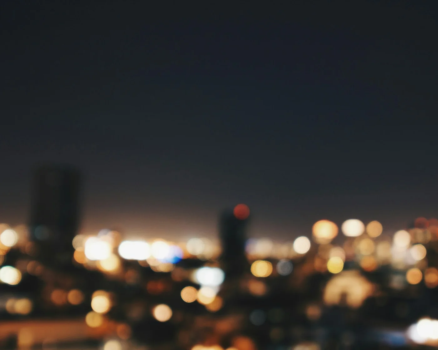 Defocused warm and gold city lights against a dark night sky, bokeh