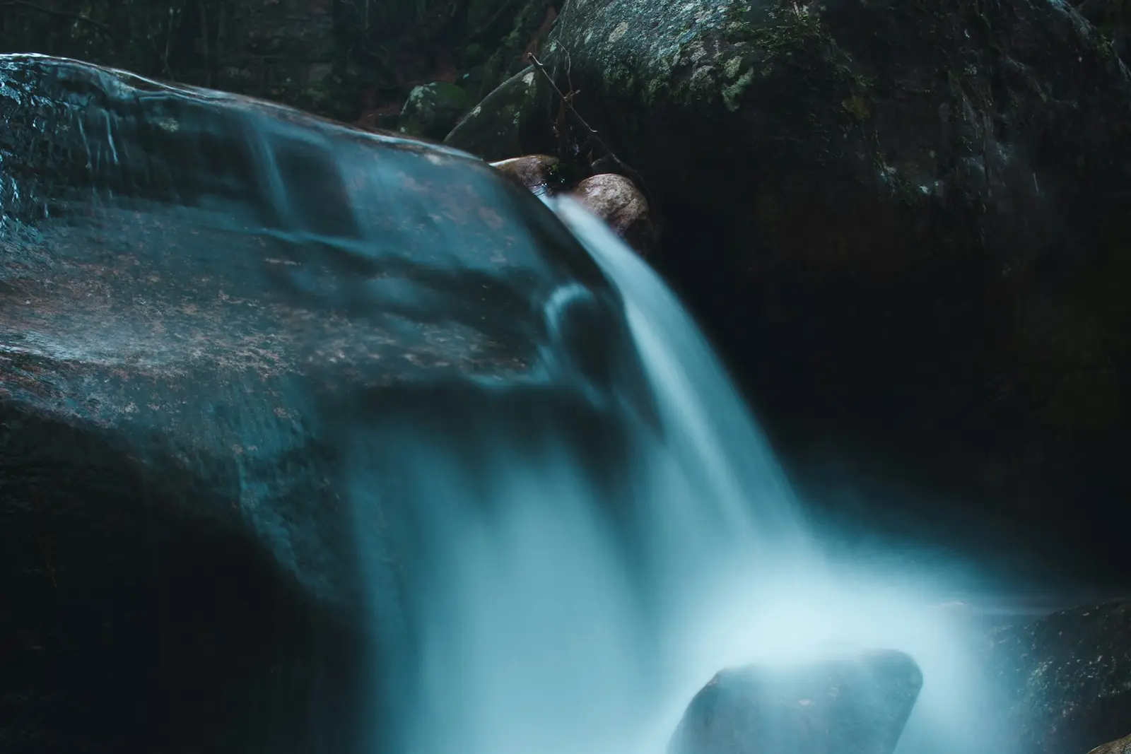 A long exposure of a small waterfall over dark rocks in Newlands Forest