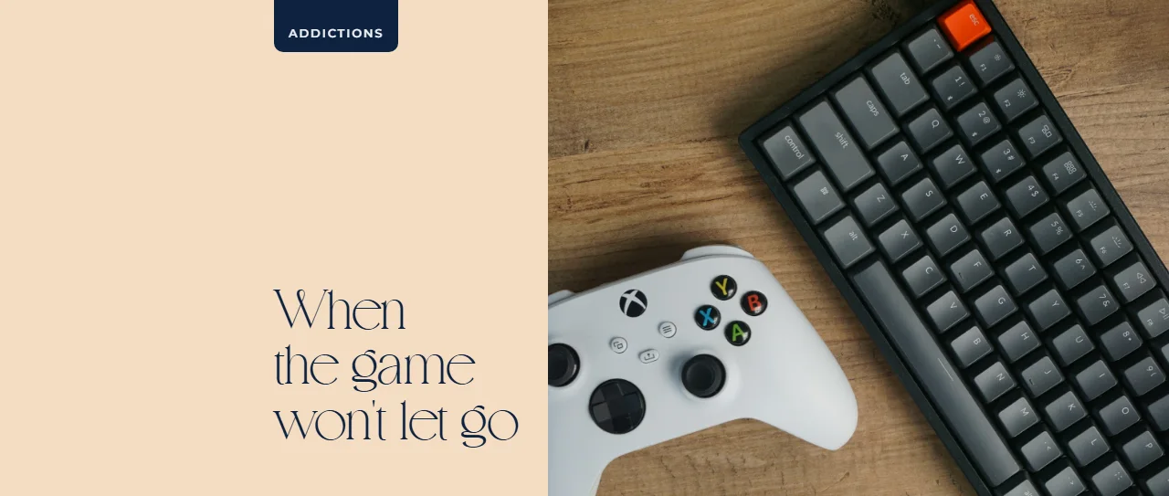 White game controller next to a keyboard on a wooden desk