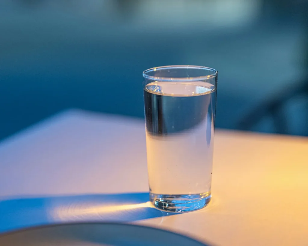 Glass of clear water on a table in warm golden light