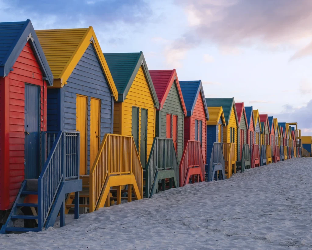 Rows of colourful Victorian bathing huts on the sand at Muizenberg beach, Cape Town