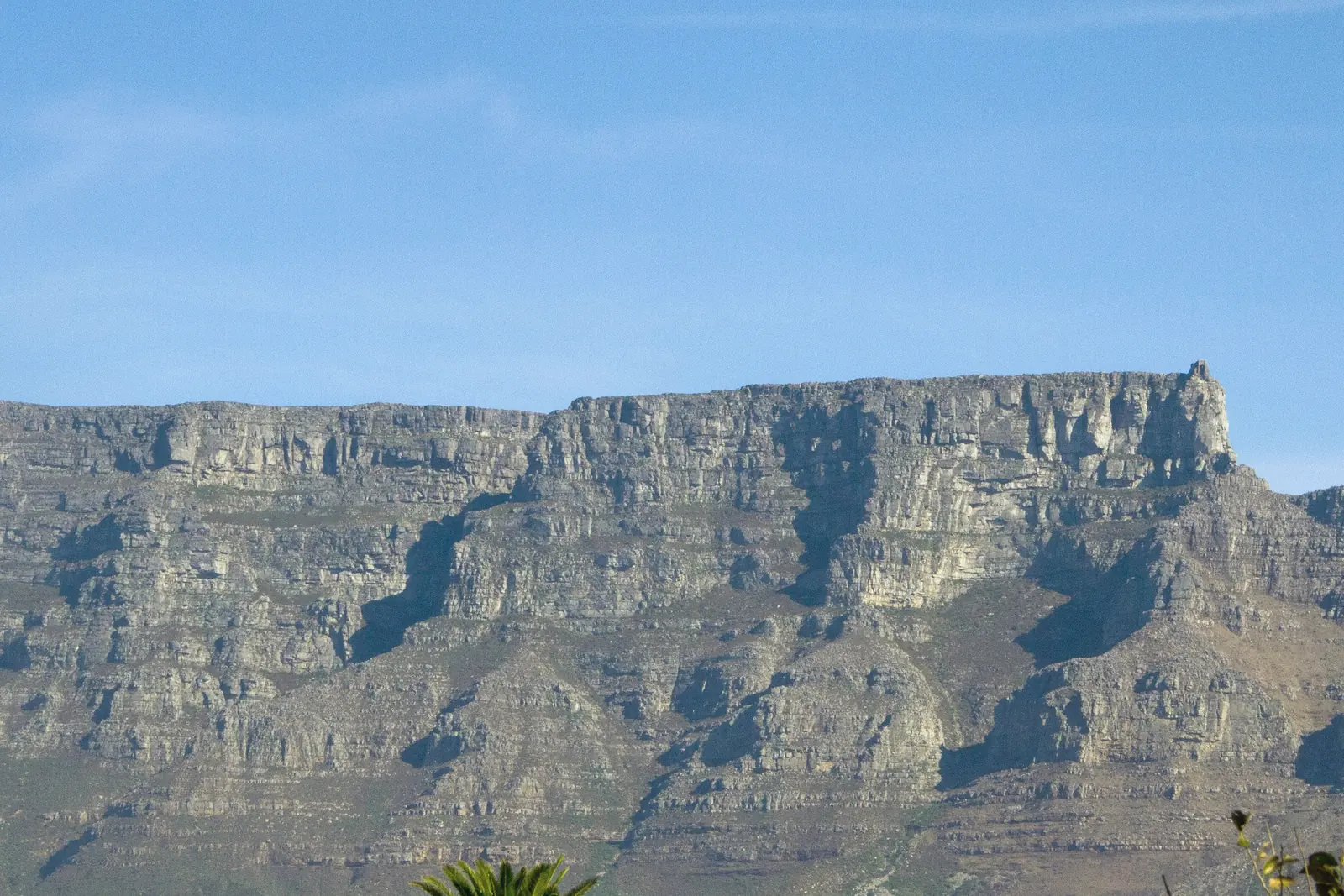 Table Mountain's flat rock face rising above Cape Town under a clear blue sky