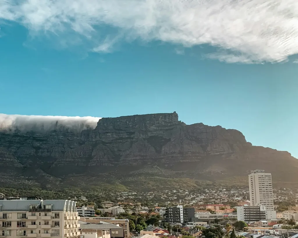 Table Mountain with a thin tablecloth of cloud above Cape Town buildings in morning sun
