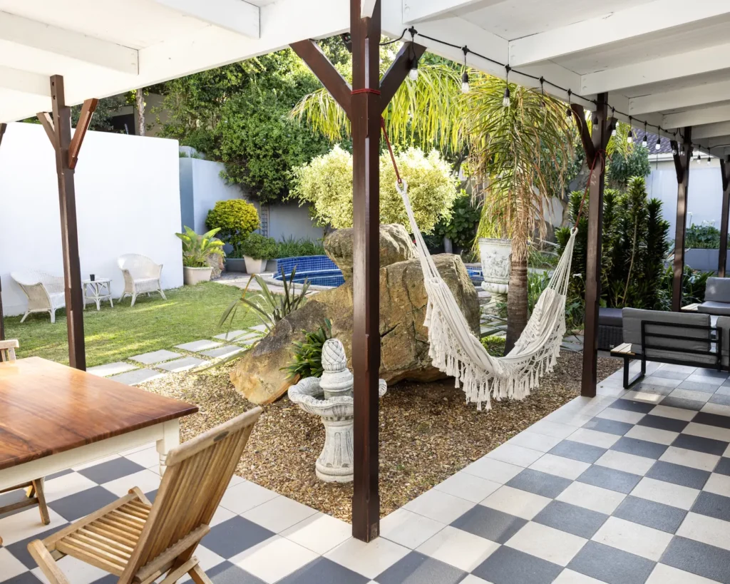 A shaded patio with hammocks and a garden lawn at Renewed Life Center in Cape Town