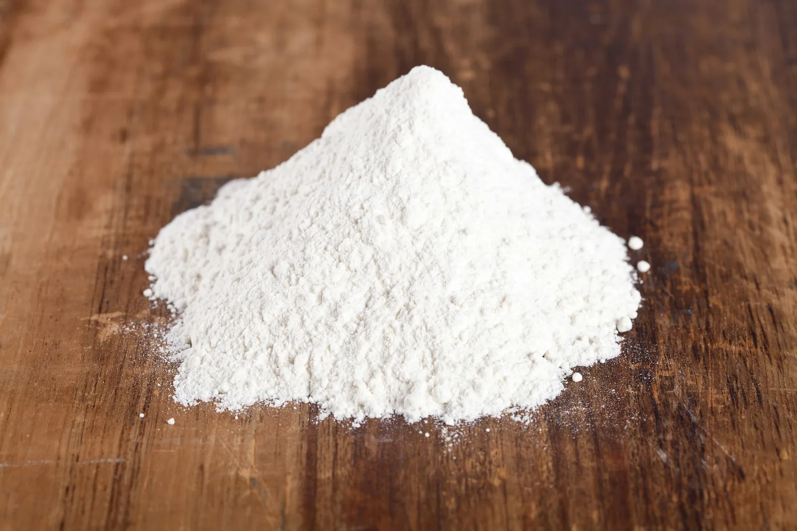 Small pile of white powder on a wooden table