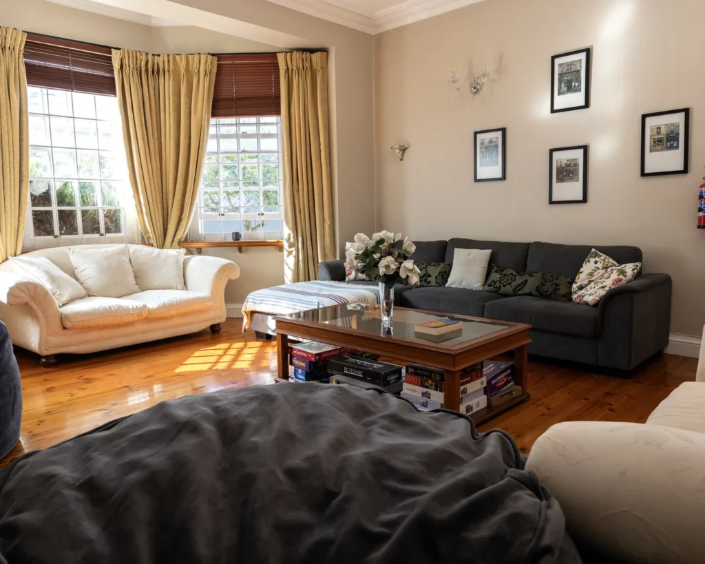 A sunny lounge with sofas, a coffee table and framed prints at Renewed Life Center